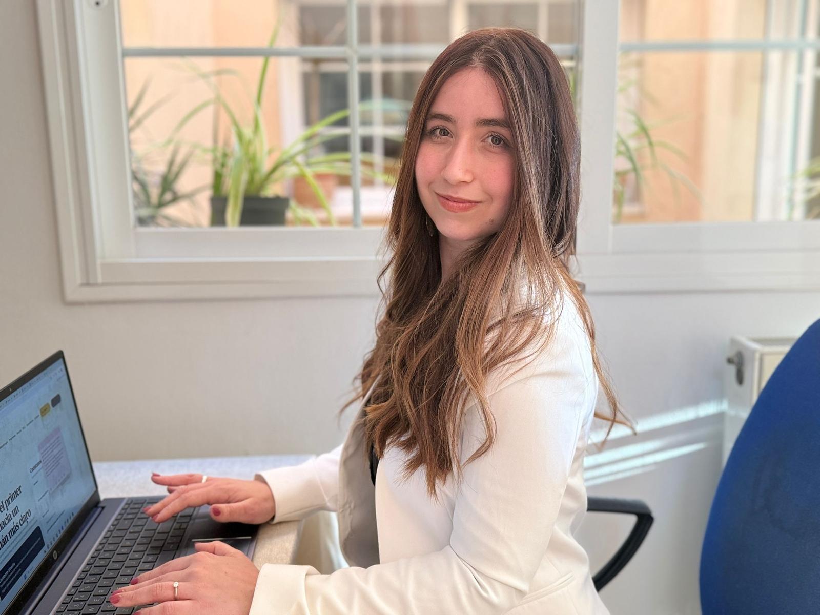 María seated at her desk